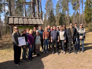 Apmācību dalībnieki pulcējušies Abavas senlejā pie informatīvā stenda, kur kopīgi iepazīst reģiona dabas un ģeoloģisko mantojumu, noslēdzot mācību dienu.