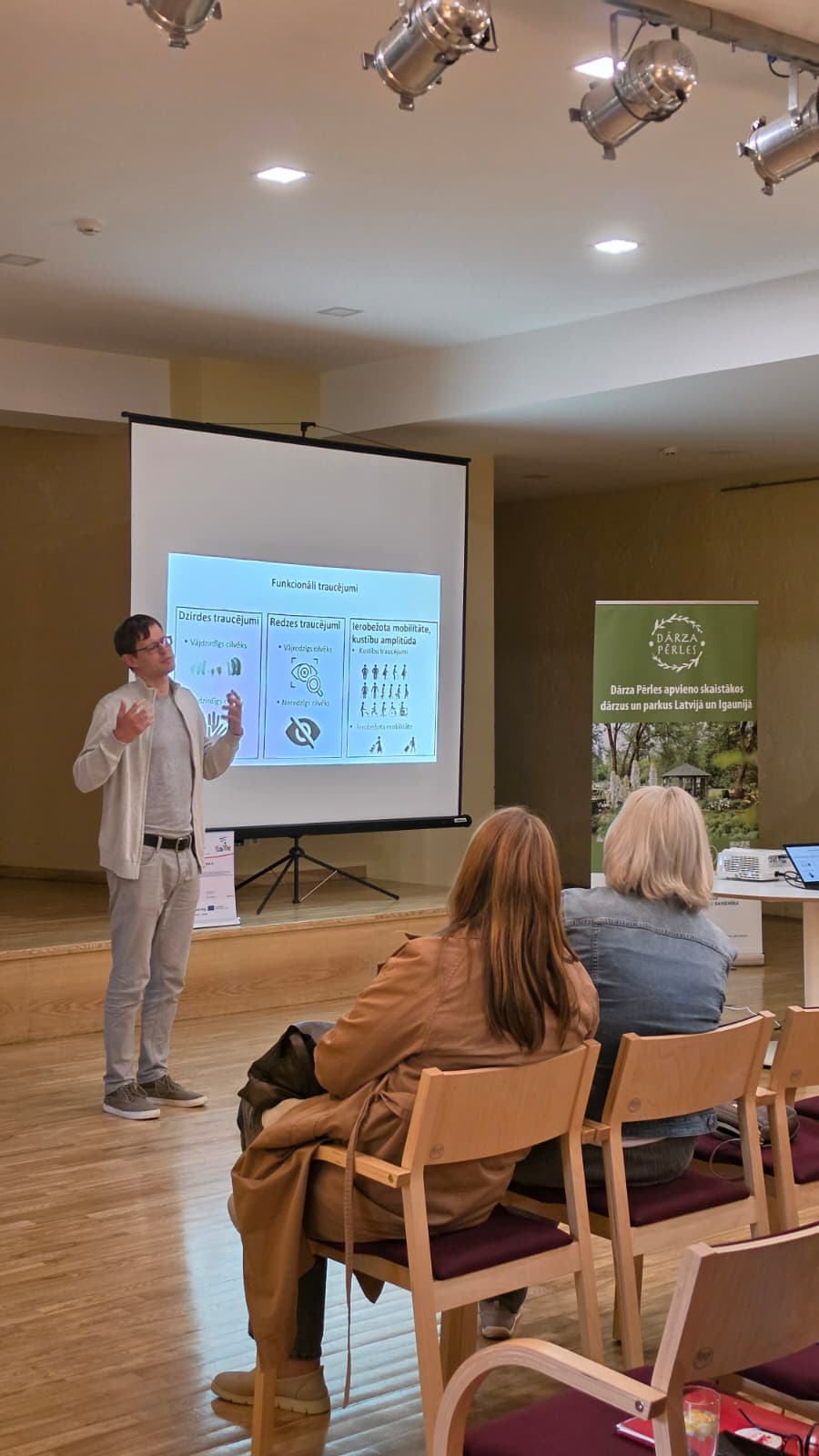Seminārā lektors stāsta par dārzu vides pieejamību cilvēkiem ar funkcionāliem traucējumiem, dalībniekiem iepazīstot praktiskus risinājumus.