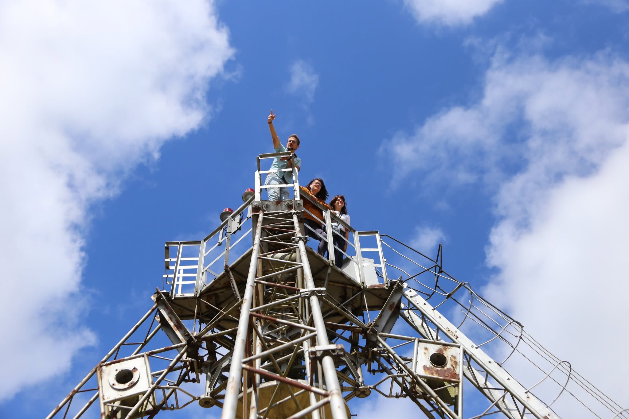 Apmeklētāji uzkāpuši Irbenes radioteleskopa konstrukcijā un vēro apkārtni no augstas skatu platformas.