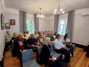 Ūdenstūrisma semināra dalībnieki Lielbornes muižas zālē sēž rindās un uzmanīgi klausās prezentāciju.